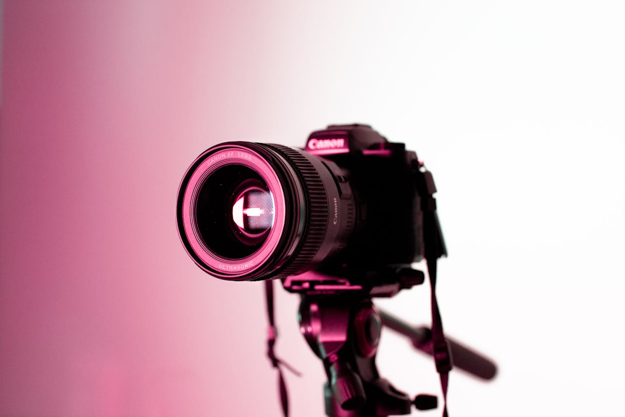 Canon DSLR camera with lens on tripod in studio lighting, perfect for photography enthusiasts.